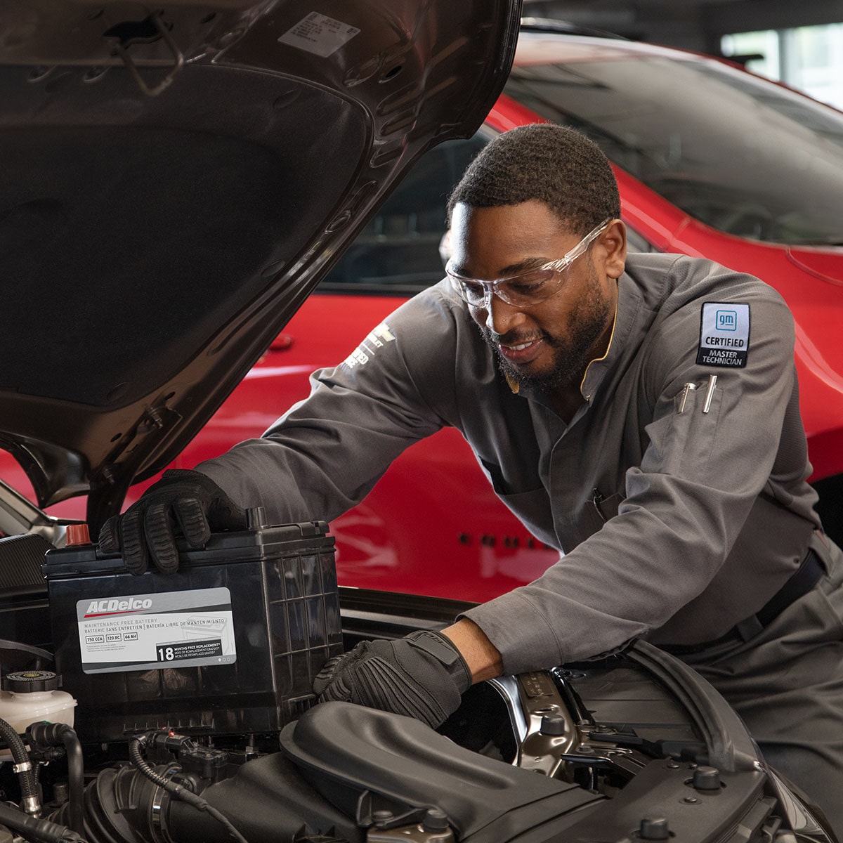 A GM Certified Automotive Technician Installs a Battery in a Vehicle