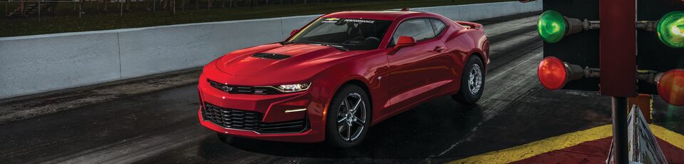 Mejoras de vehículos con partes Chevy Performance: Toma de medio perfil del extremo delantero de auto deportivo Camaro rojo