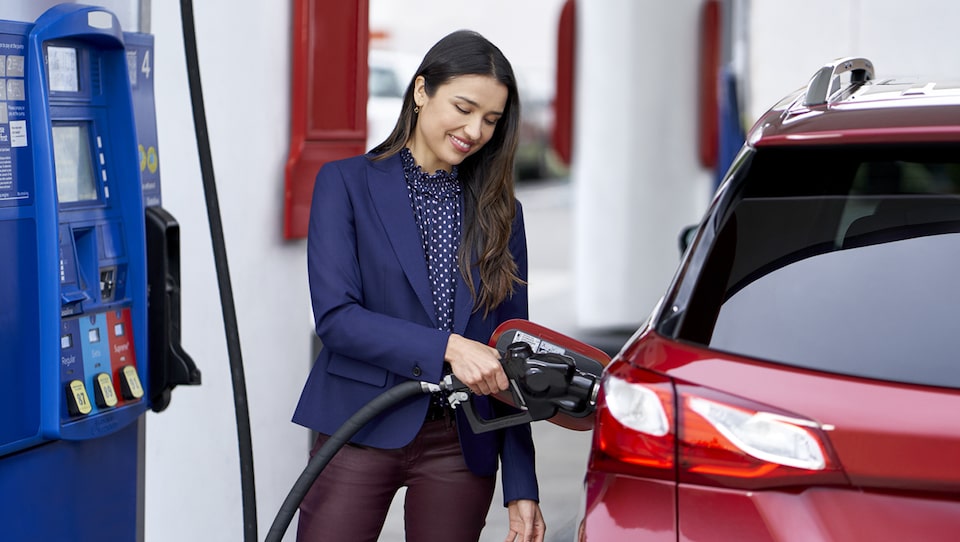 Mujer cargando combustible a su vehículo Chevrolet con la tarjeta GM Business Card