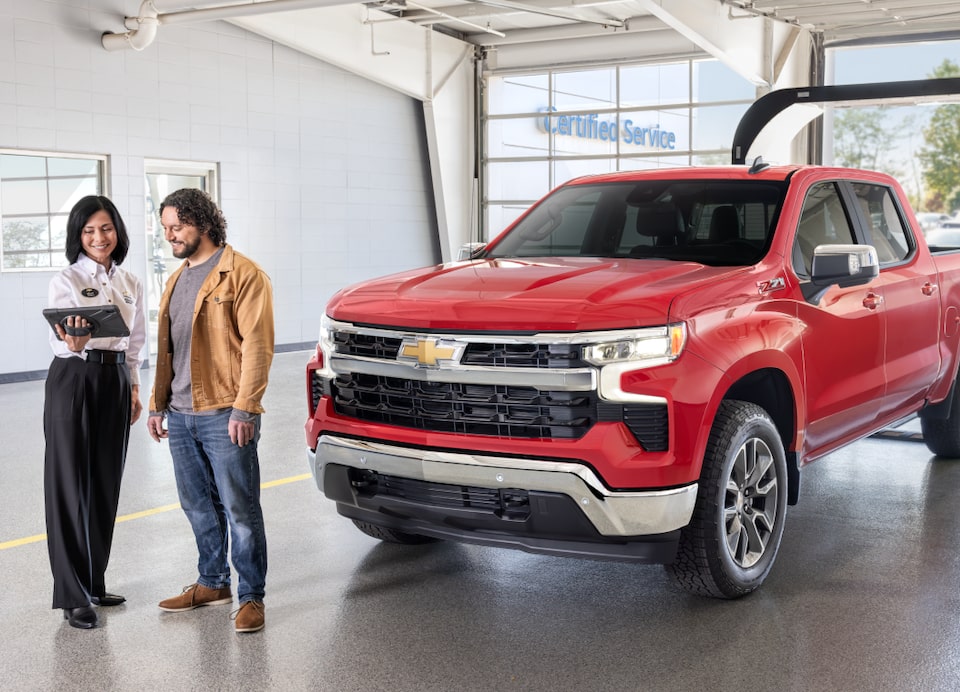 Employee and customer next to red truck