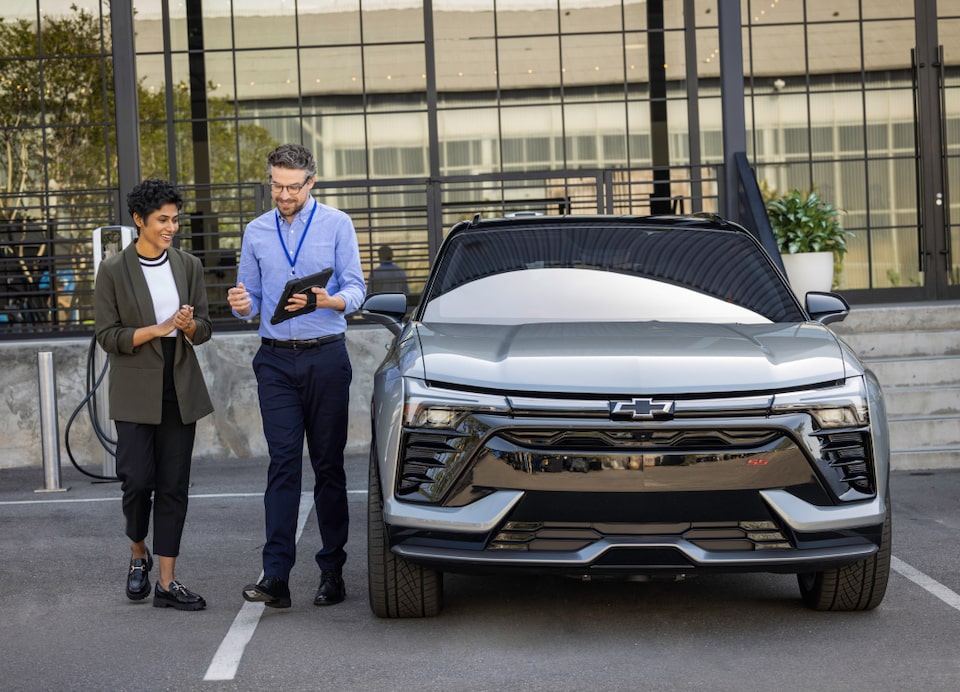 Employee and customer next to car