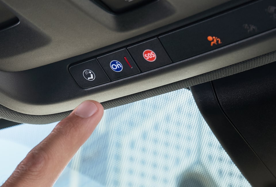 Conductor presionando el botón de servicios OnStar en vehículo Chevrolet