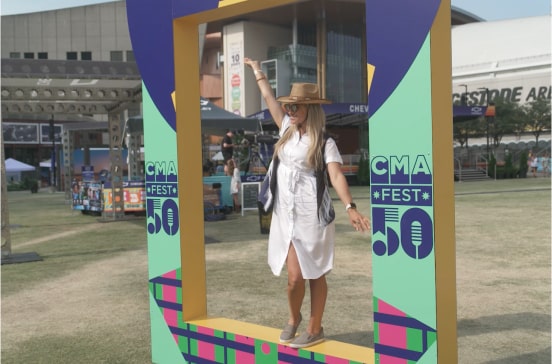 A CMA Fest attendant poses for a photo op