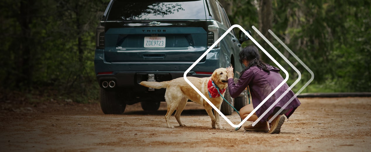 woman with dog in front of a Tahoe