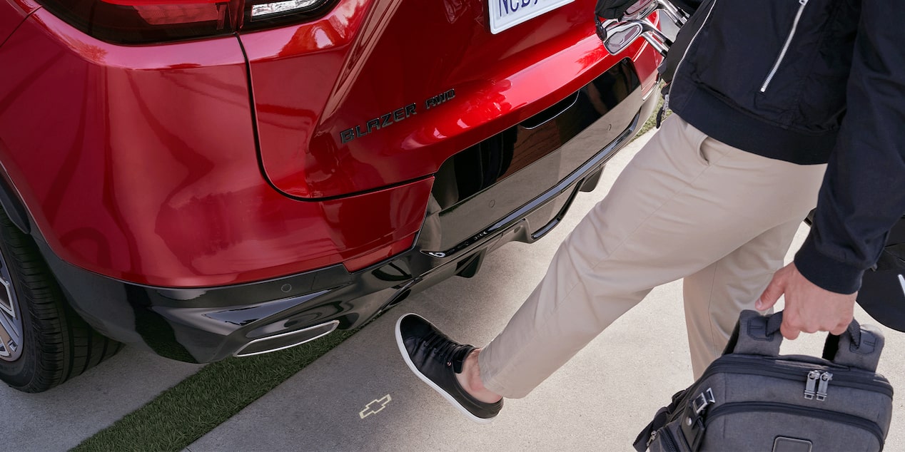 A Man Using His Leg to Alarm the Sensor of a Red 2026 Chevy Blazer to Open Its Trunk