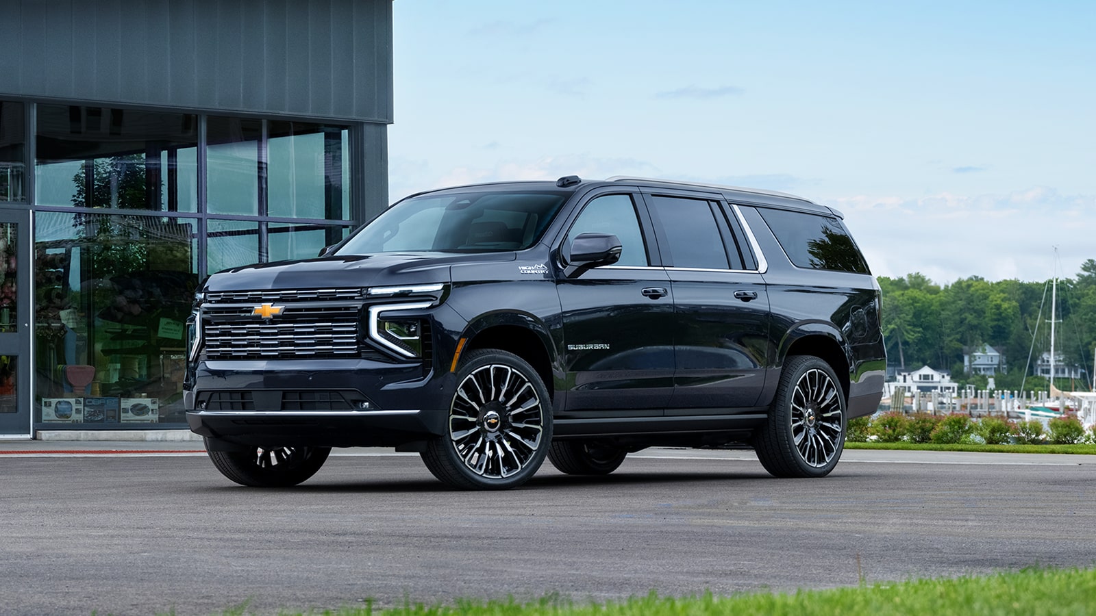 Front Three-quarters View of a 2026 Chevy Suburban SUV Parked in Front of a Business