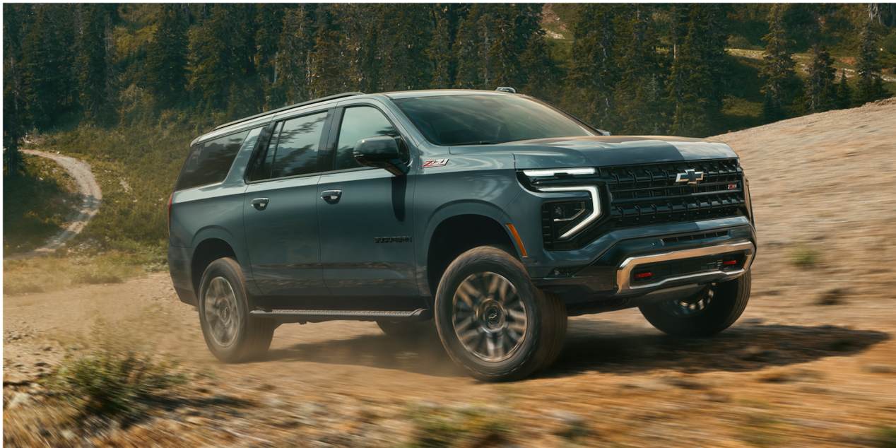 Three-quarters View of the 2026 Chevy Suburban SUV Off-roading in a Wooded Area