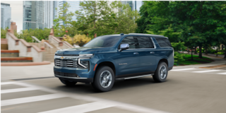 Three-quarters View of the 2026 Chevy Suburban SUV Driving Through the City