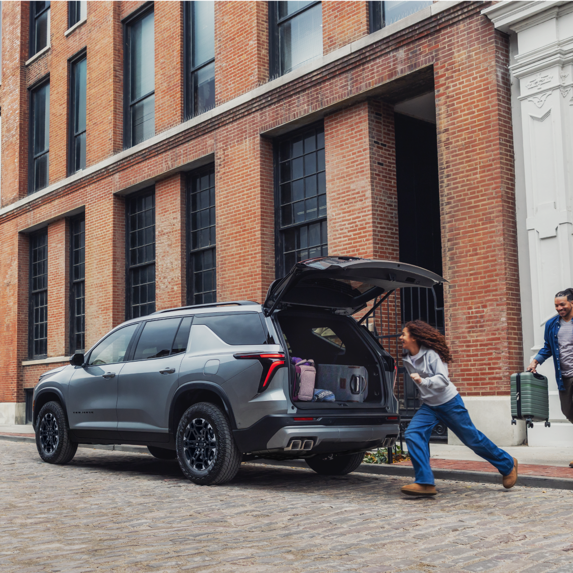 A 2027 Chevy Traverse Parked on a City Street With the Rear Liftgate Open for Cargo Loading and Unloading.