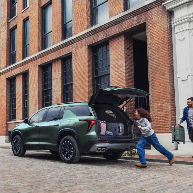 A 2027 Chevy Traverse Parked on a City Street With the Rear Liftgate Open for Cargo Loading and Unloading.
