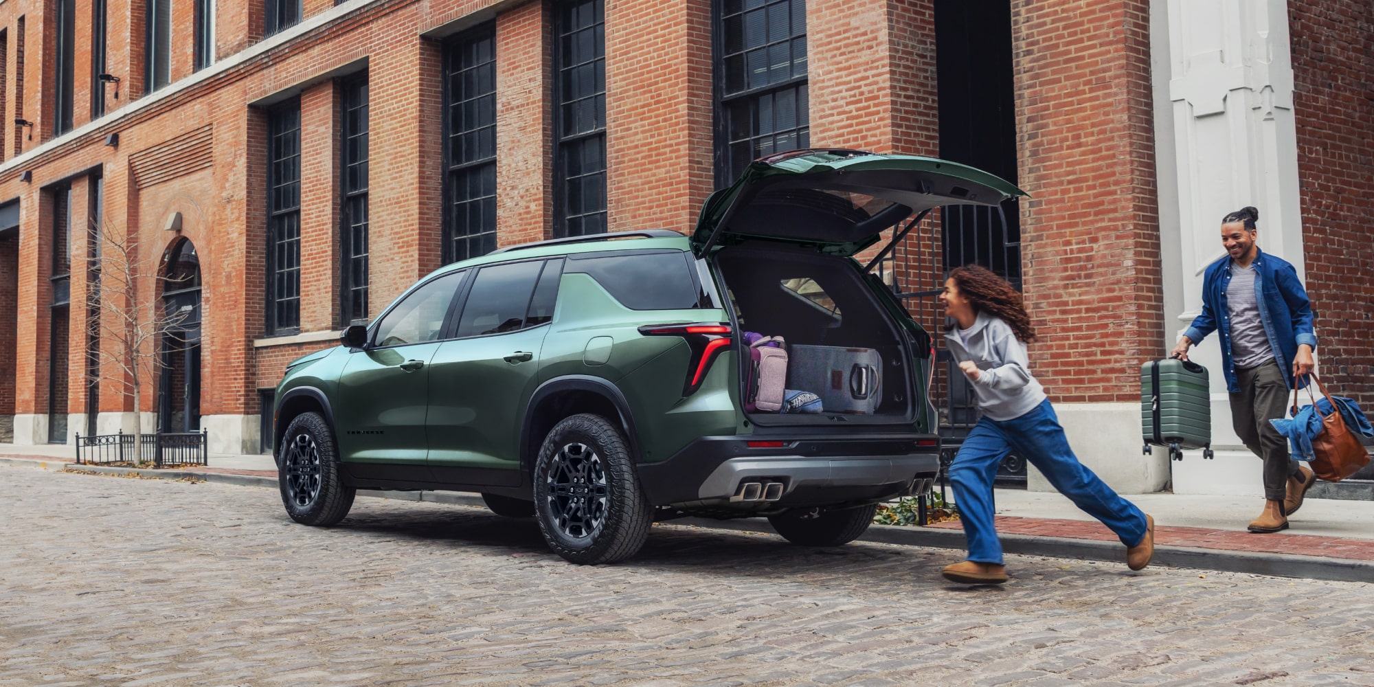 A 2027 Chevy Traverse Parked on a City Street With the Rear Liftgate Open for Cargo Loading and Unloading.