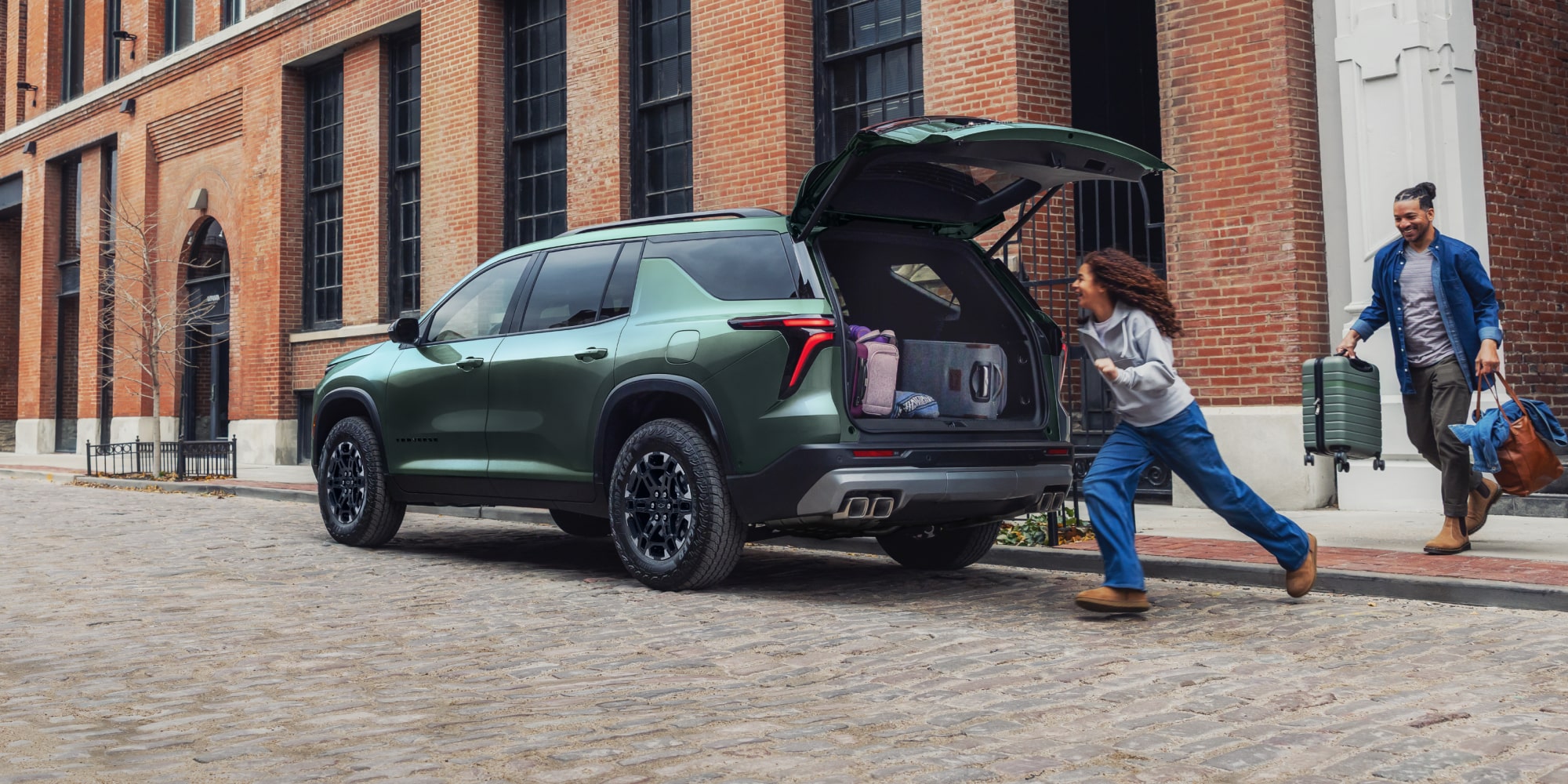 A 2027 Chevy Traverse Parked on a City Street With the Rear Liftgate Open for Cargo Loading and Unloading.