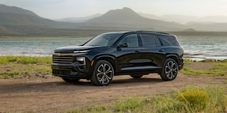 Profile View of an All-black 2027 Chevy Traverse Parked Next to a Lake by the Mountains
