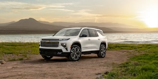 A White 2027 Chevy Traverse Parked by a Lake During a Sunrise Over the Mountains