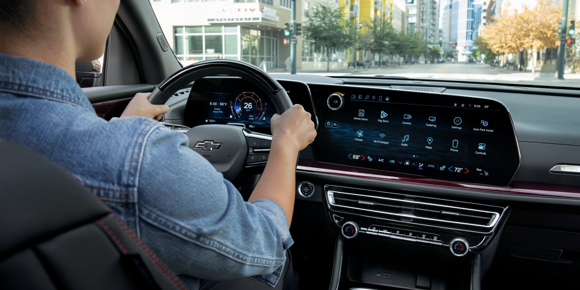 A Driver Using the Infotainment Touchscreen in a 2027 Chevy Traverse Featuring a Large Center Display and Integrated Vehicle Controls.