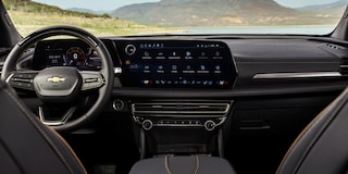 Back Seat View of the 2027 Chevy Traverse Front Row Interior and Dashboard While Outlooking the Mountains