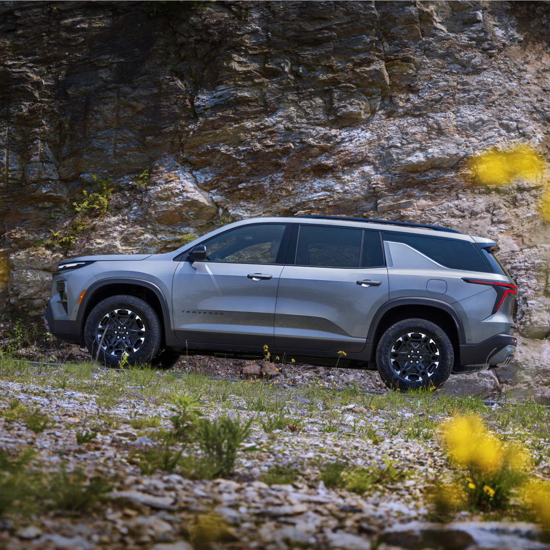 A 2027 Chevy Traverse Parked on a Forest Trail With a Scenic Outdoor Backdrop.