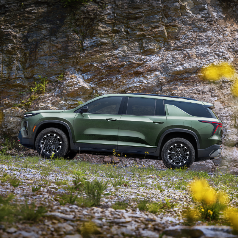 A 2027 Chevy Traverse Parked on a Forest Trail With a Scenic Outdoor Backdrop.