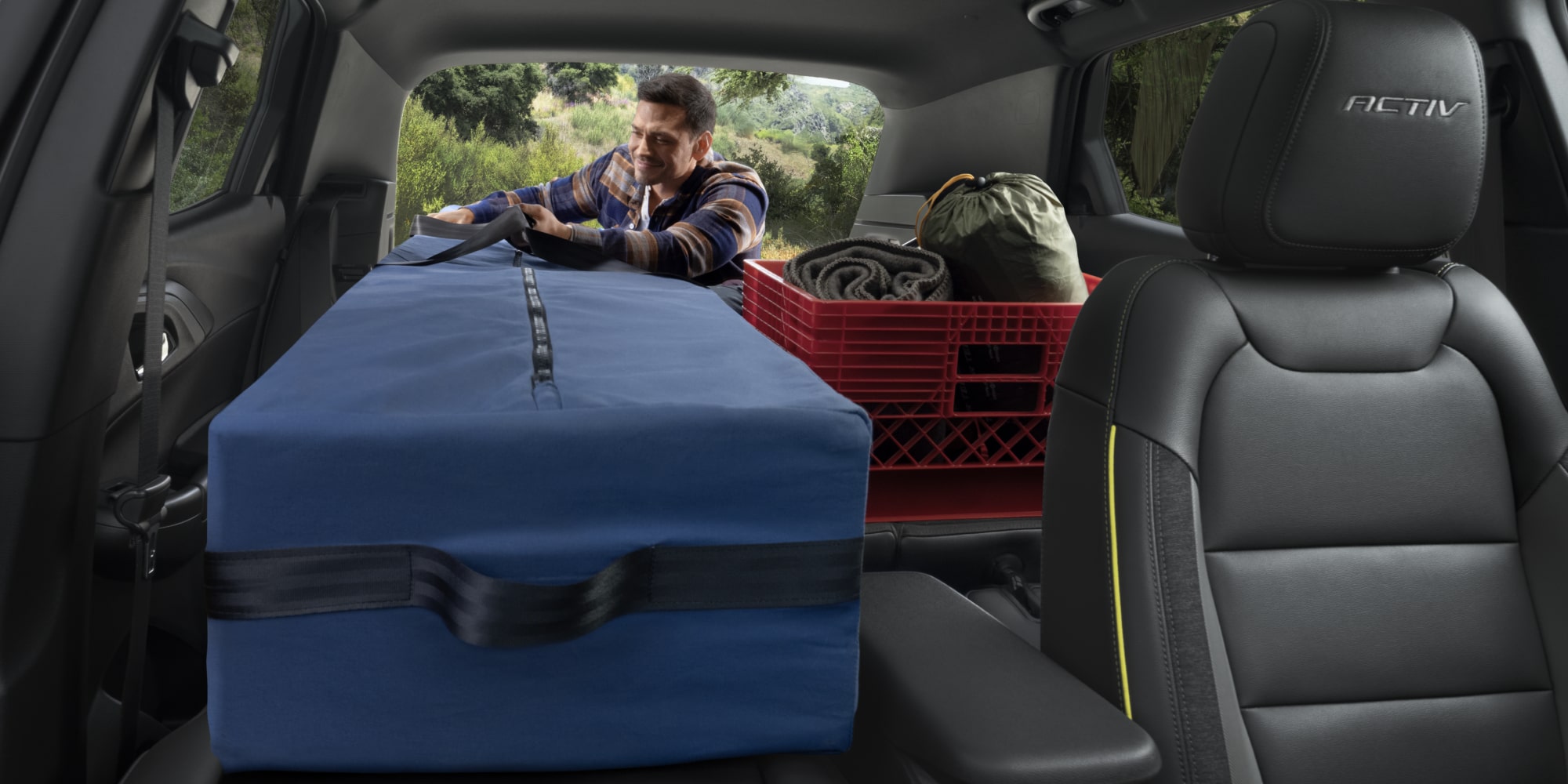 Back Seat View of a Man Loading Camping Gear Inside of the Spacious Trunk of a Chevy Trailblazer