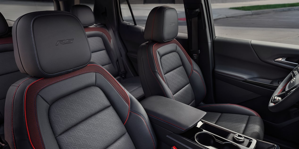 The Interior of a Chevrolet Equinox Showcasing Black Leather Seats With Red Accents and ACTIV Branding on the Headrests.
