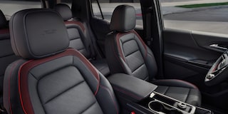 The Interior of a Chevrolet Equinox Showcasing Black Leather Seats With Red Accents and ACTIV Branding on the Headrests.