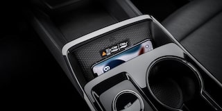 A Center Console Storage Area Inside a Chevrolet Equinox Holding Small Personal Items Next to Dual Cupholders.