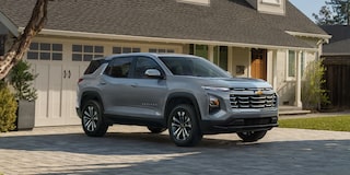 A Silver Chevrolet Equinox Parked in Front of a Suburban Home With Sunlight Casting Soft Shadows Across the Driveway.