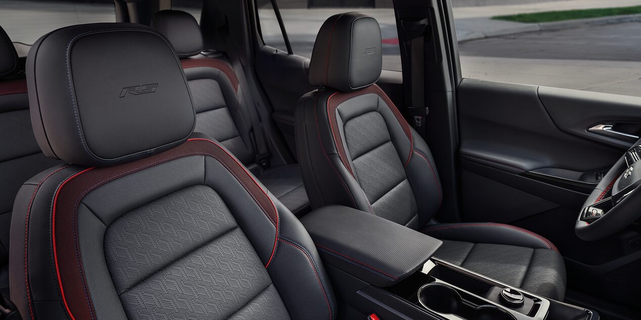 The Interior of a Chevrolet Equinox Showcasing Black Leather Seats With Red Accents and ACTIV Branding on the Headrests.
