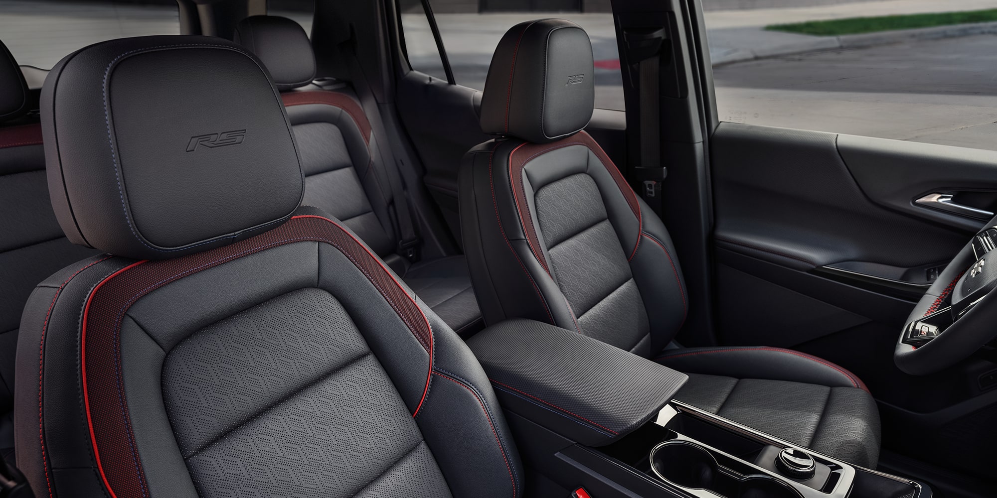 The Interior of a Chevrolet Equinox Showcasing Black Leather Seats With Red Accents and ACTIV Branding on the Headrests.