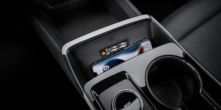 A Center Console Storage Area Inside a Chevrolet Equinox Holding Small Personal Items Next to Dual Cupholders.