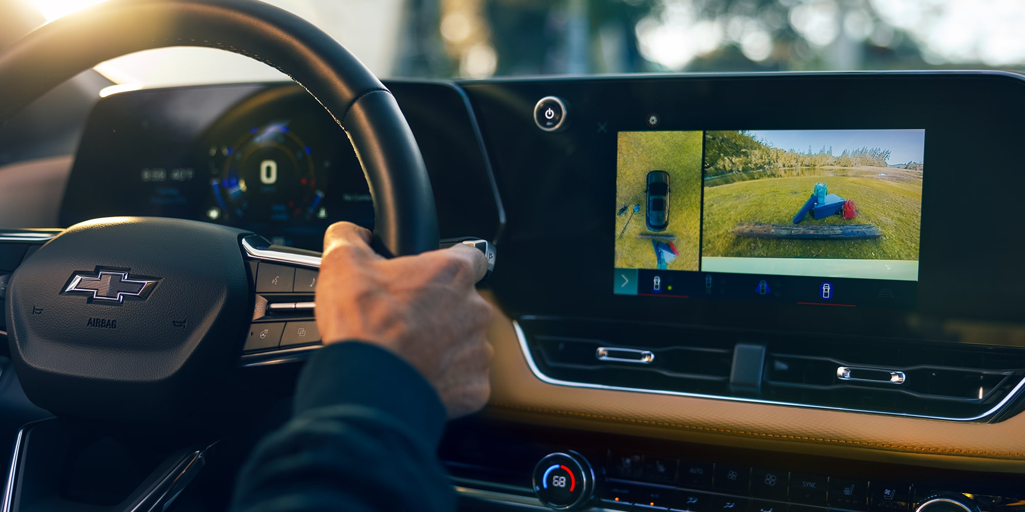 A Driver Inside a Chevrolet Equinox Interacting With the Central Touchscreen Display Showing a Camera View While Holding the Steering Wheel.