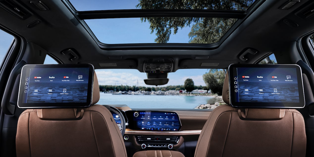 The Interior of a Chevrolet Suburban Featuring Dual Rear-Seat Entertainment Screens, a Panoramic Sunroof, and a Wide Central Infotainment Display.