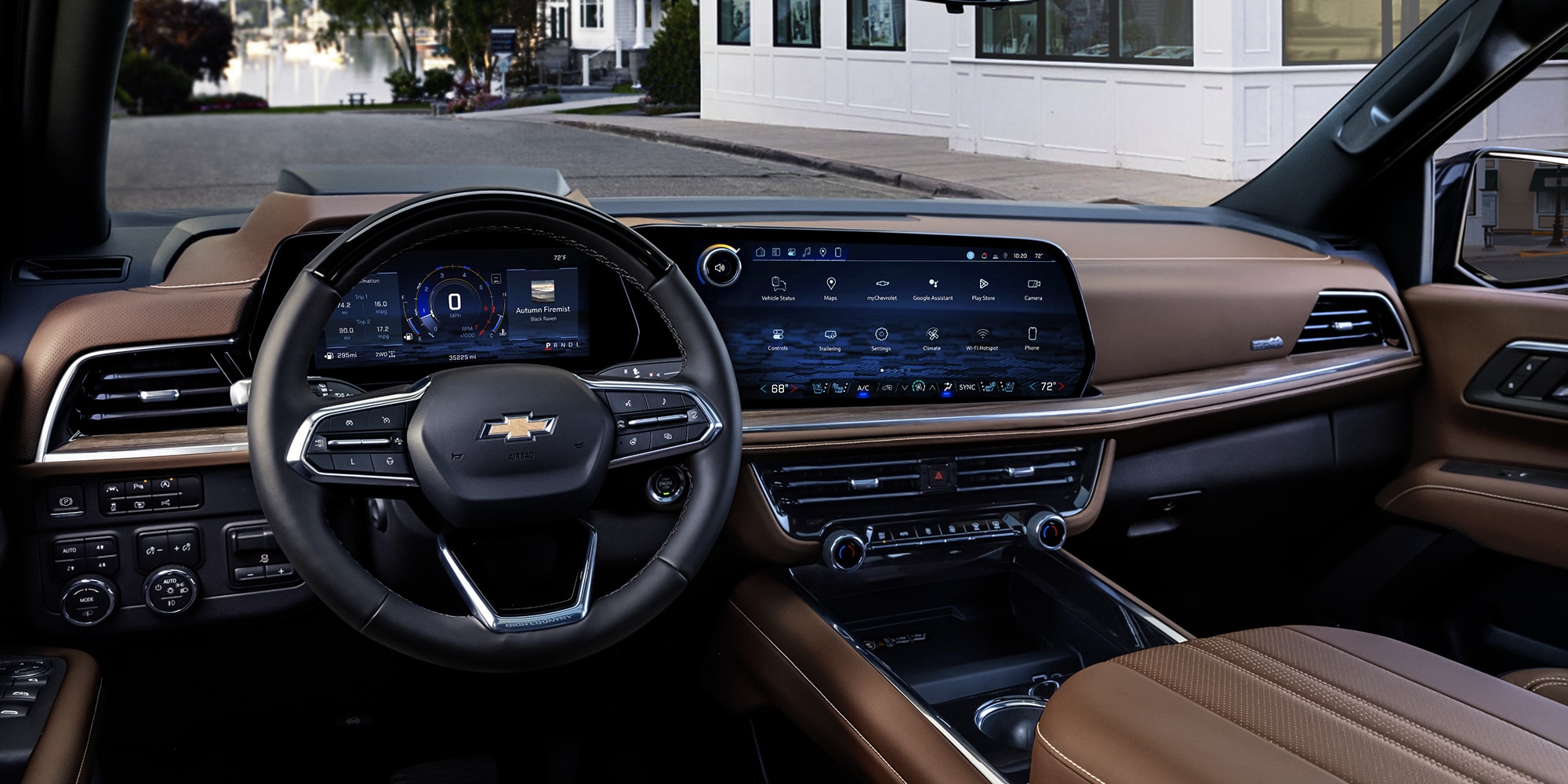 The Driver’s View Inside a Chevrolet Suburban Featuring a Leather-Wrapped Steering Wheel, a Digital Gauge Cluster, and a Wide Touchscreen Display.