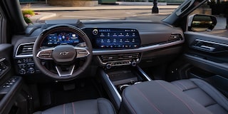 The Interior of a Chevrolet Tahoe Showcasing a Leather-Wrapped Steering Wheel, a Large Digital Infotainment Screen, and Premium Cabin Materials.