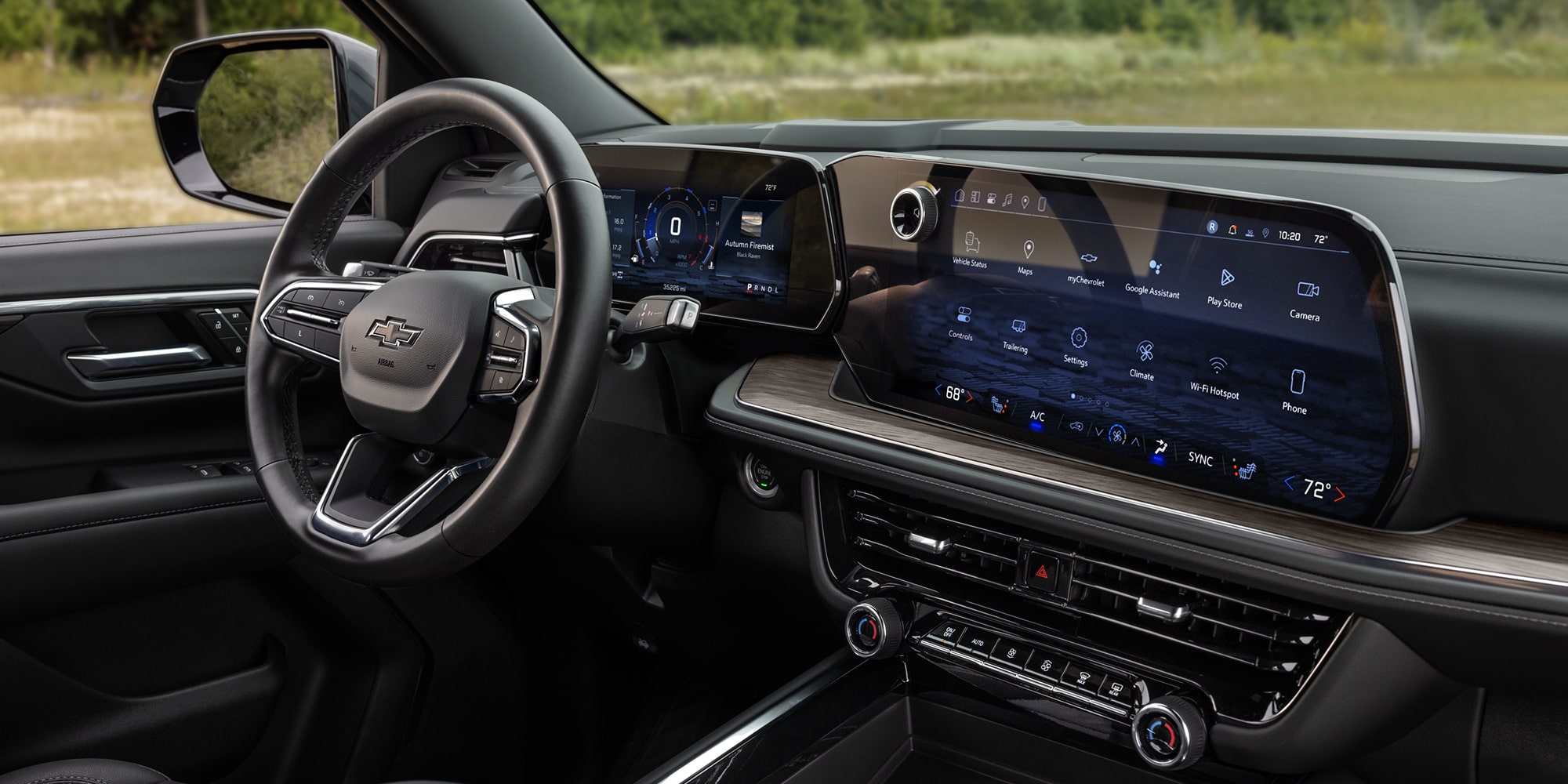 The Interior of a Chevrolet Tahoe Featuring a Leather-Wrapped Steering Wheel and a Wide Digital Infotainment Display Across the Dashboard.