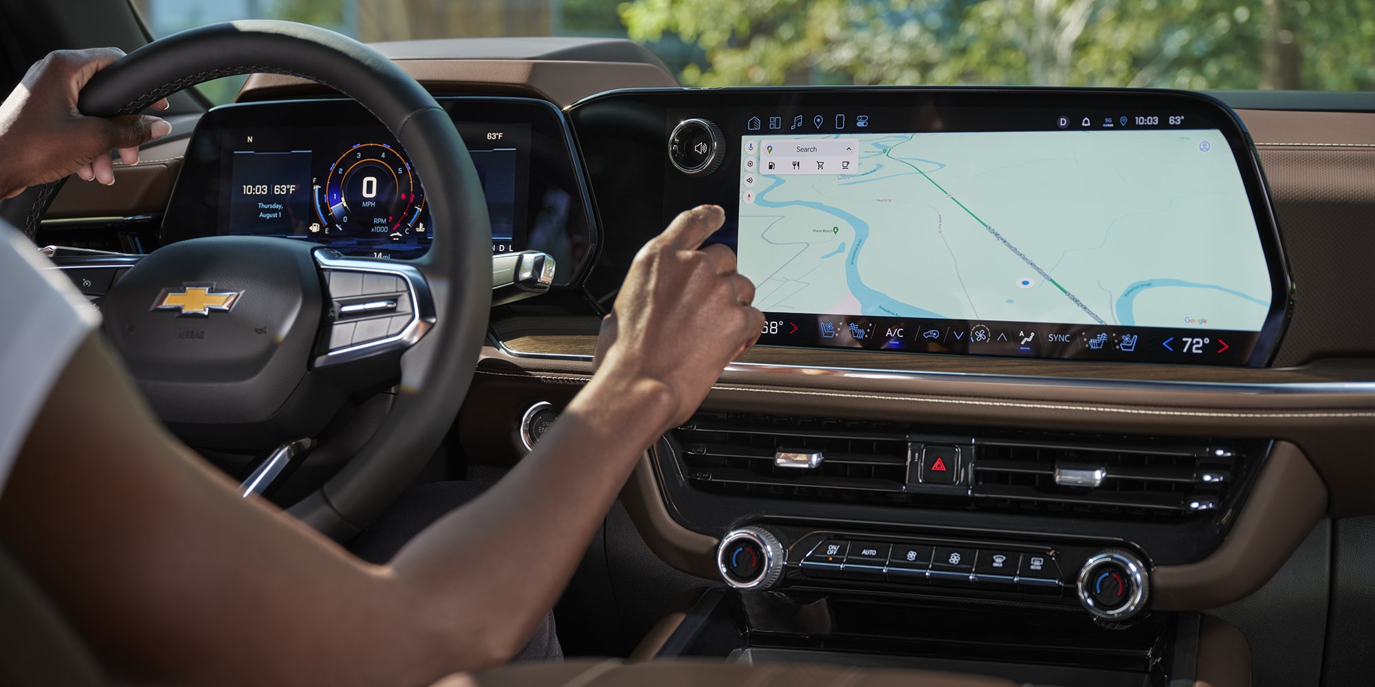 A Driver Inside a Chevrolet Tahoe Using the Large Central Touchscreen Display While Navigating a Map Interface.