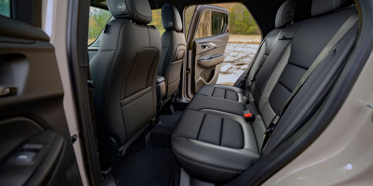 El interior de una Chevrolet Trailblazer que muestra los amplios asientos traseros negros vistos desde la puerta abierta de los pasajeros traseros.