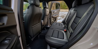 El interior de una Chevrolet Trailblazer que muestra los amplios asientos traseros negros vistos desde la puerta abierta de los pasajeros traseros.