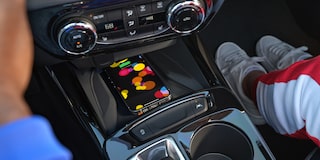 A Smartphone Displaying a Colorful Screen Resting on the Wireless Charging Pad Within the Center Console of a Chevrolet Trax