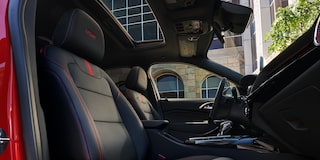 The Front Row Interior Cabin of a Chevrolet Trax Featuring Black Seats With Red Stitching, and a Panoramic Sunroof