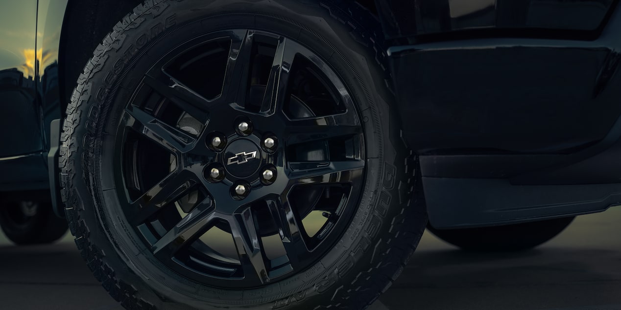 Close-Up of a Black Alloy Wheel with an Off-Road Tire and a Chevrolet Logo in the Center