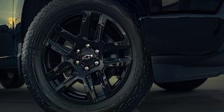 Close-Up of a Black Alloy Wheel with an Off-Road Tire and a Chevrolet Logo in the Center