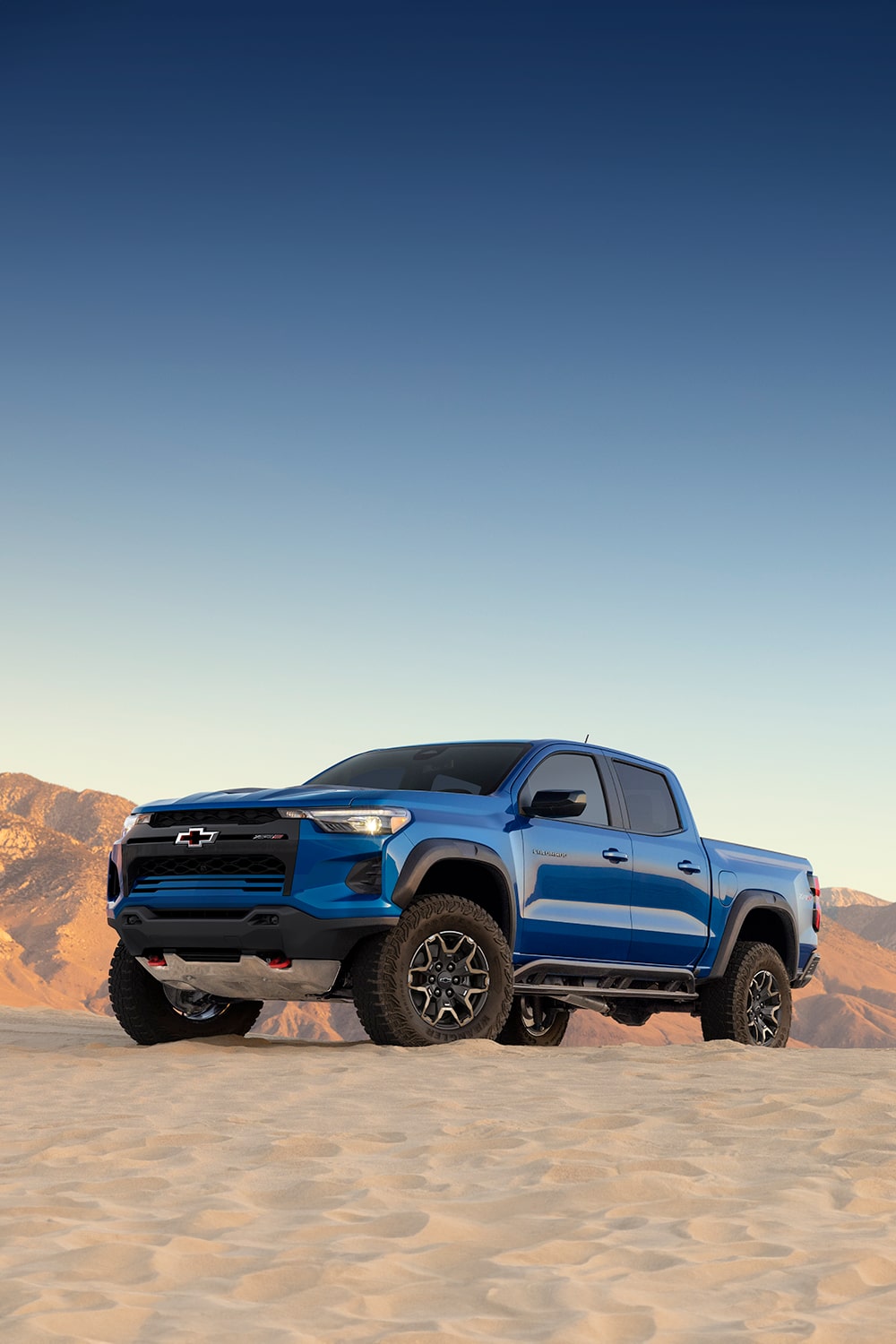 Three quarter view of a 2026 Blue Chevy Colorado in a desert