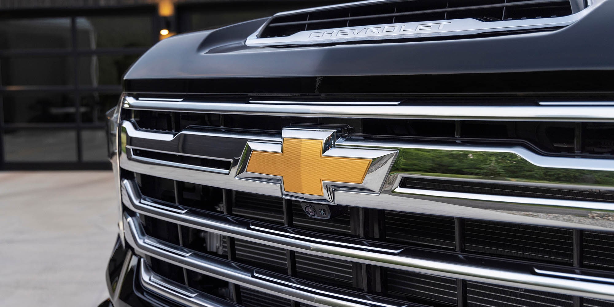 Chrome grille and gold bowtie badge of a 2026 Chevrolet Silverado HD