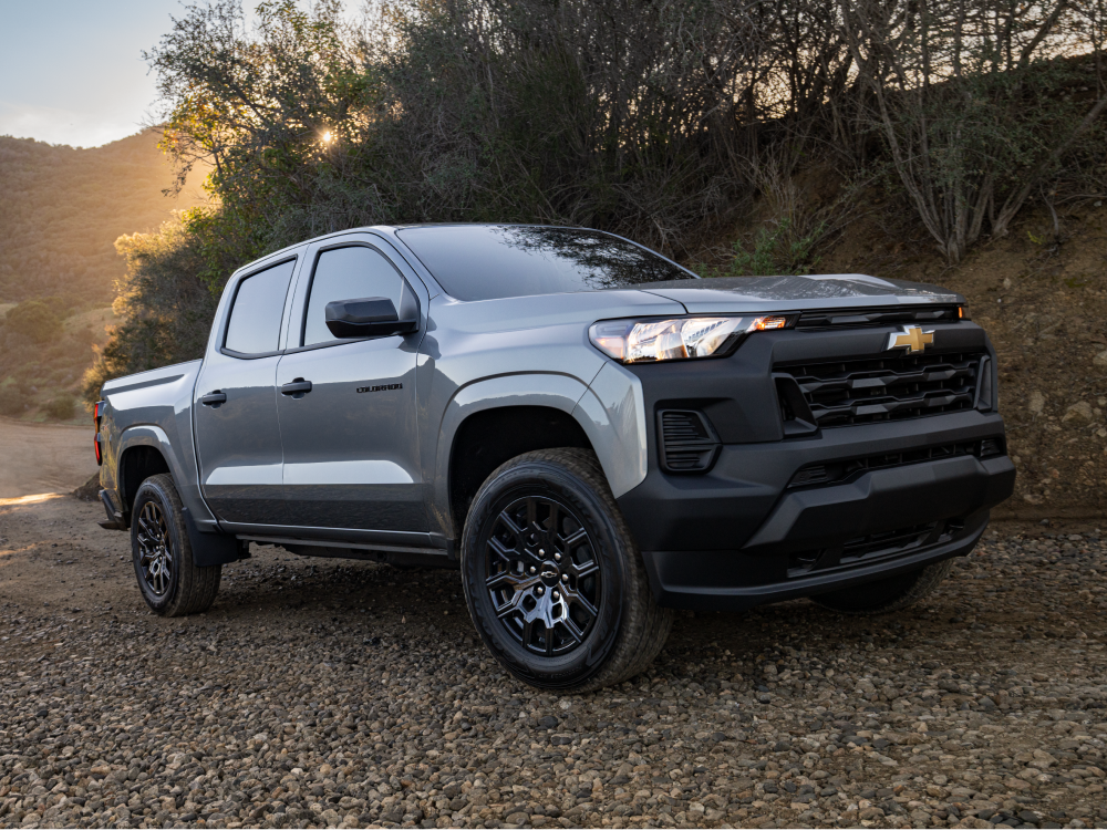 A Chevy Colorado Parked on a Gravel Surface Surrounded by Trees and Outdoor Scenery.