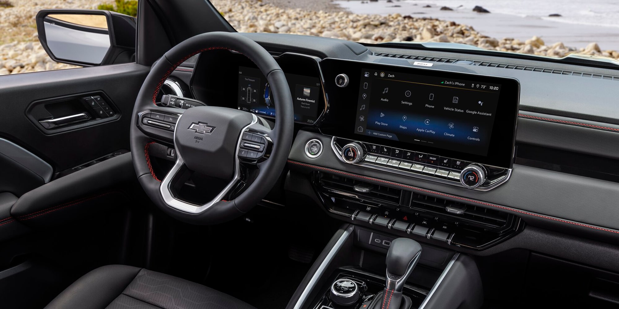 Interior of a Chevy Colorado Showing the Steering Wheel, Digital Displays, Center Console, and Front Seating Area.