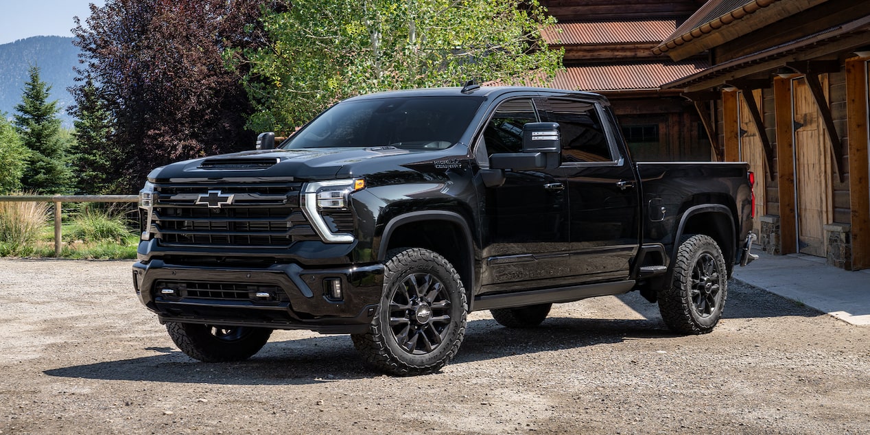 A Black Chevy Silverado HD Parked in a Driveway Beside a Garage