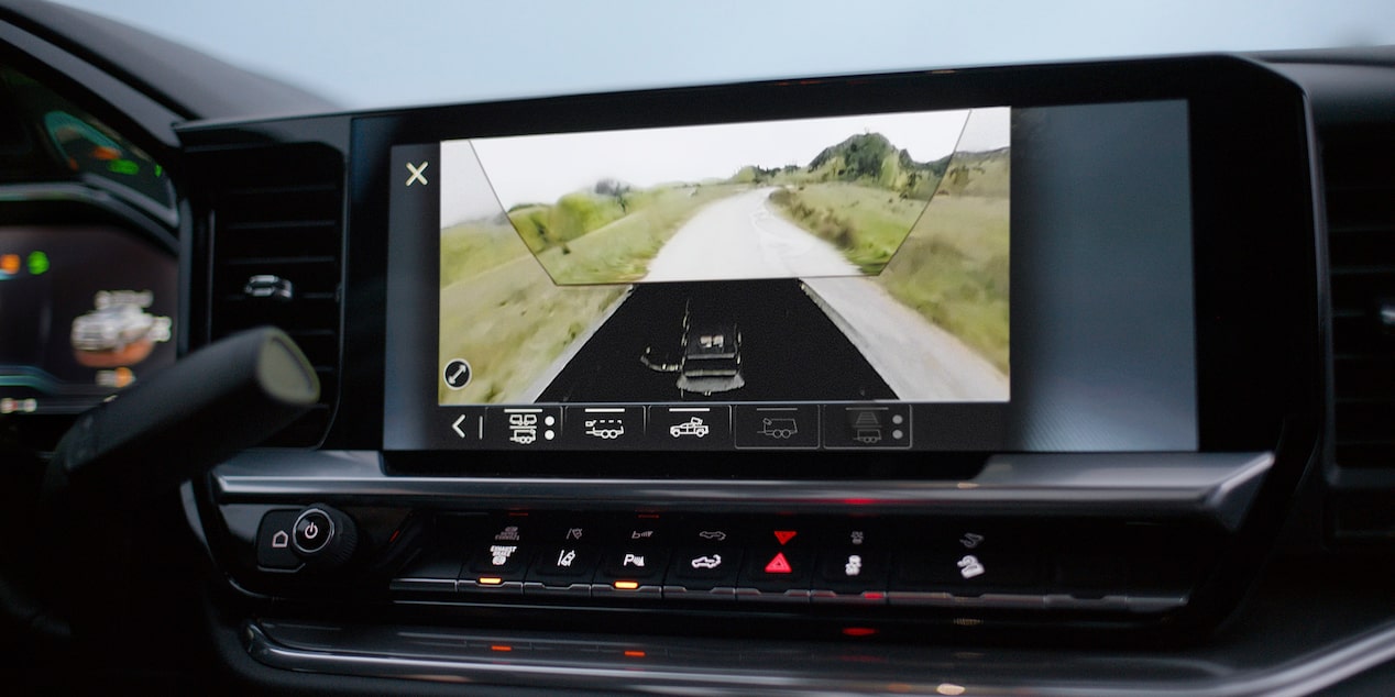 A Close-Up View of the Chevy Silverado HD Center Touchscreen Displaying a Rear Trailer Camera Perspective With Guidance Lines for Enhanced Trailering Visibility