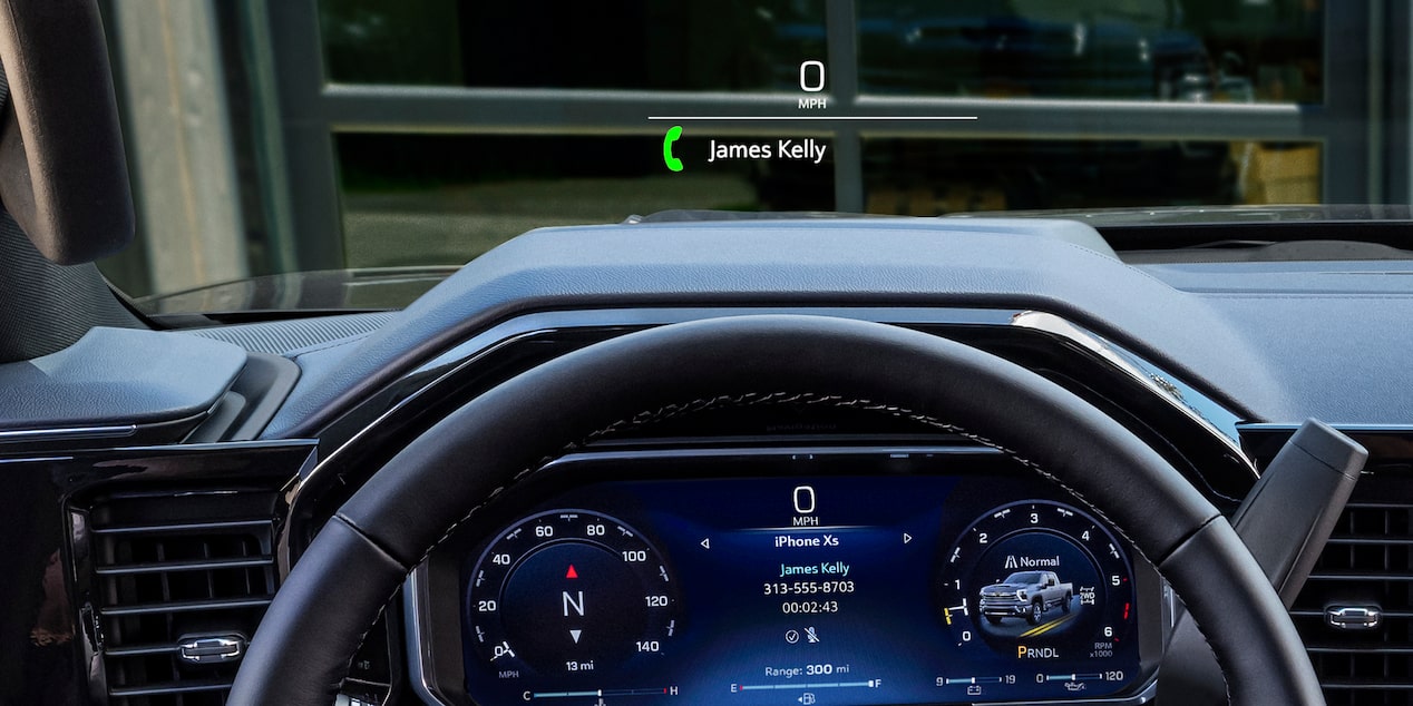 A Driver’s View Inside a Chevy Silverado HD Showing the Head-Up Display Projecting Vehicle Information Above the Steering Wheel and Instrument Panel