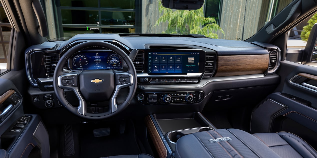 A Wide View of the Premium Interior of a Chevy Silverado HD Featuring a Digital Driver Display, Large Center Touchscreen, Wood-Grain Trim, and Leather-Appointed Seats